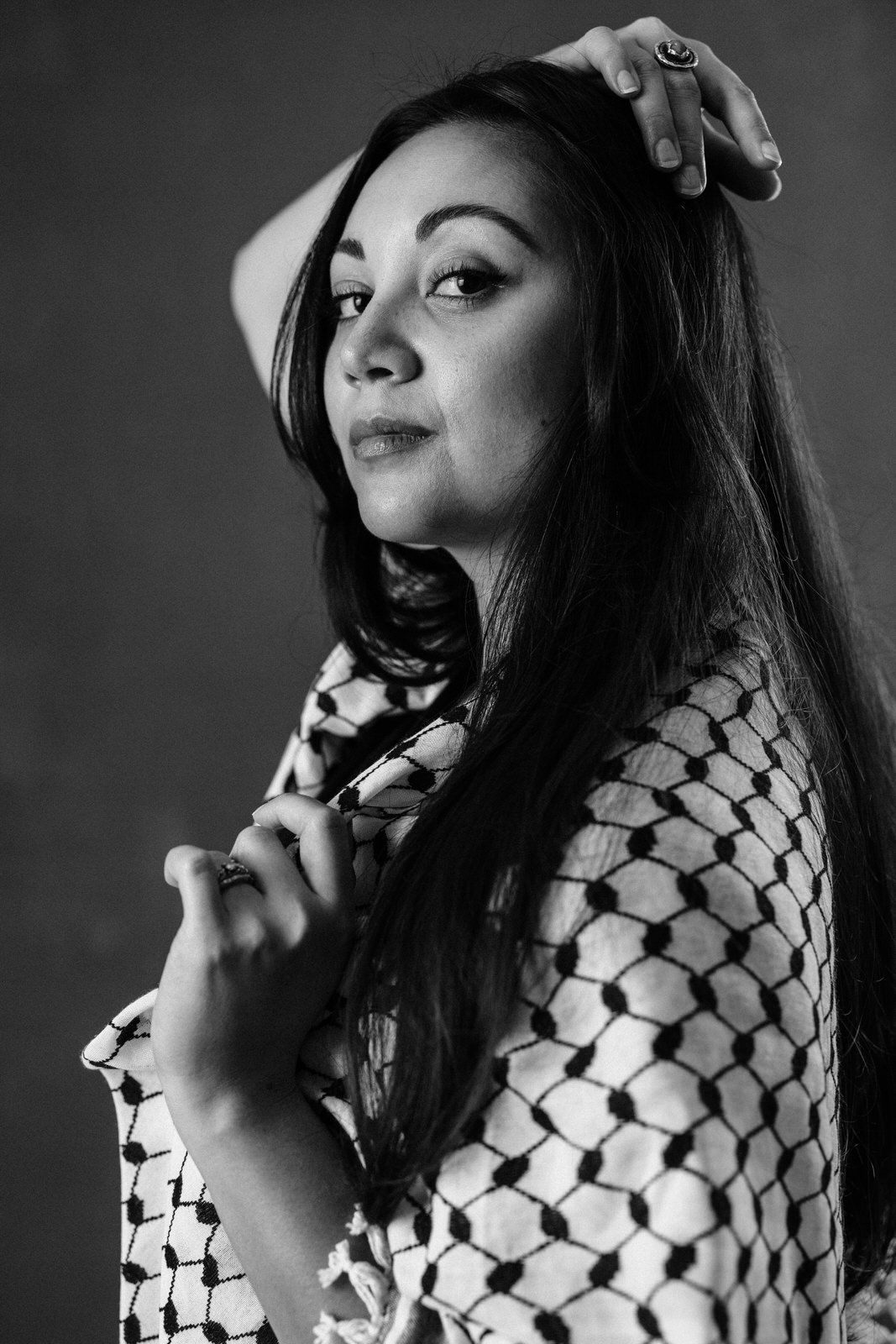 Black and white portrait of woman with long dark hair wearing a black scarf over her shoulders.