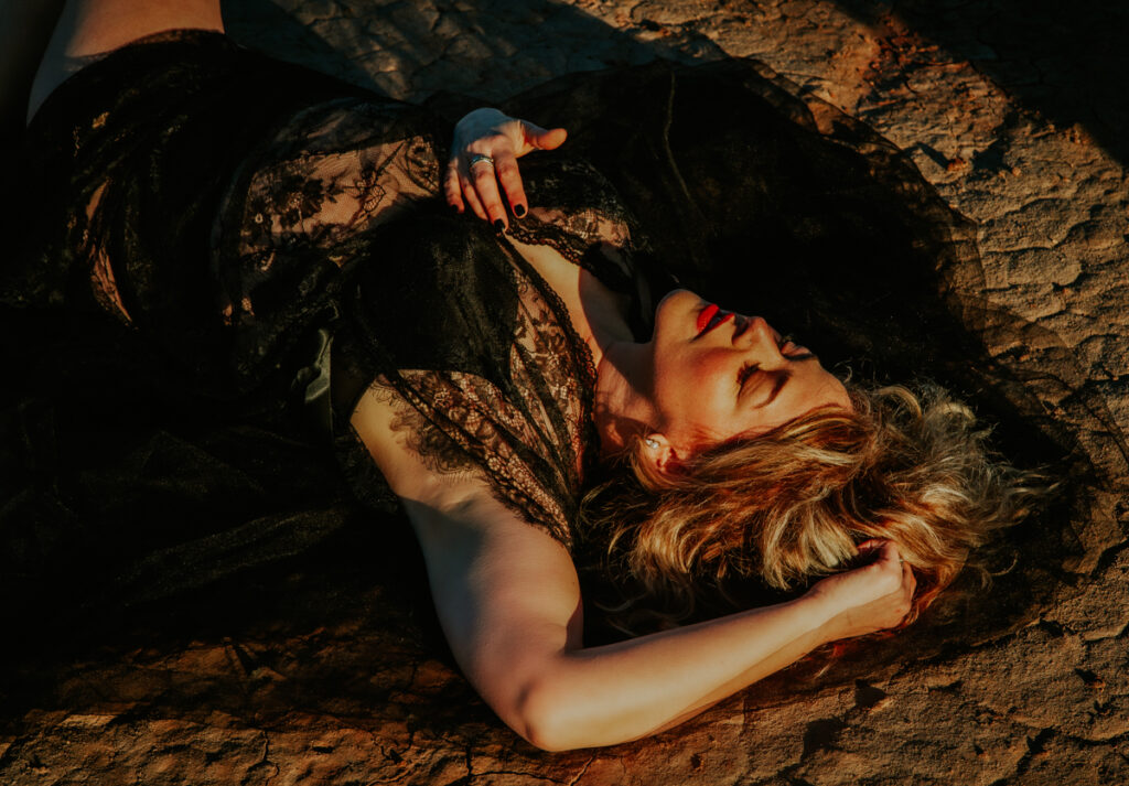Woman in lace outfit laying on the ground