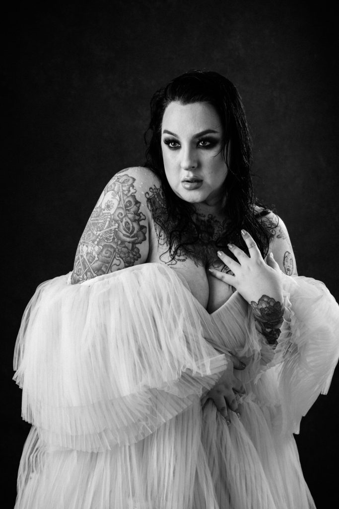 woman in an off shoulder gown exposing her cleavage and tattoos