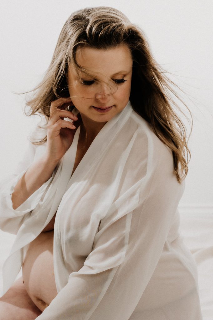 pregnant woman sitting wearing robe