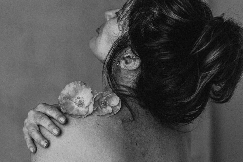 Vancouver Boudoir Photographer Michele Mateus creates portraits of women embodying their feminine energy. PIctured here is a woman connecting with a flower in a meditative moment.