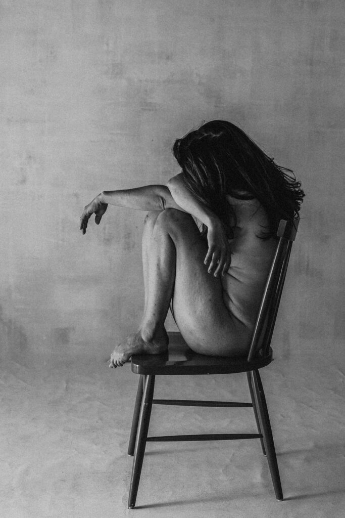 Portrait of a nude woman sat on a wooden chair by Vancouver Fine art portrait photographer Michele Mateus