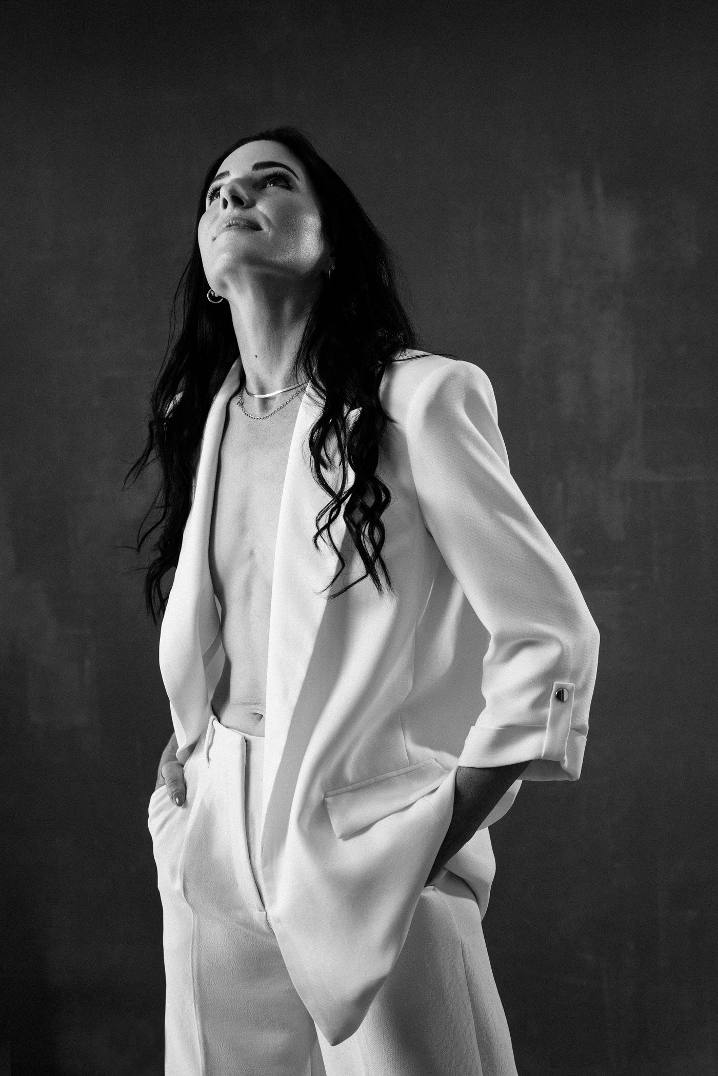 Portrait of a white woman with long black hair in a modern white suit by Vancouver Portrait Photographer Michele Mateus