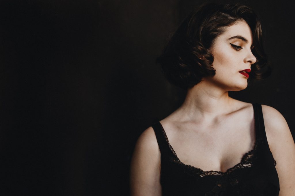 Portrait of a woman with short brown hair and red lips in slip ace top taken by portrait photographer Michele Mateus