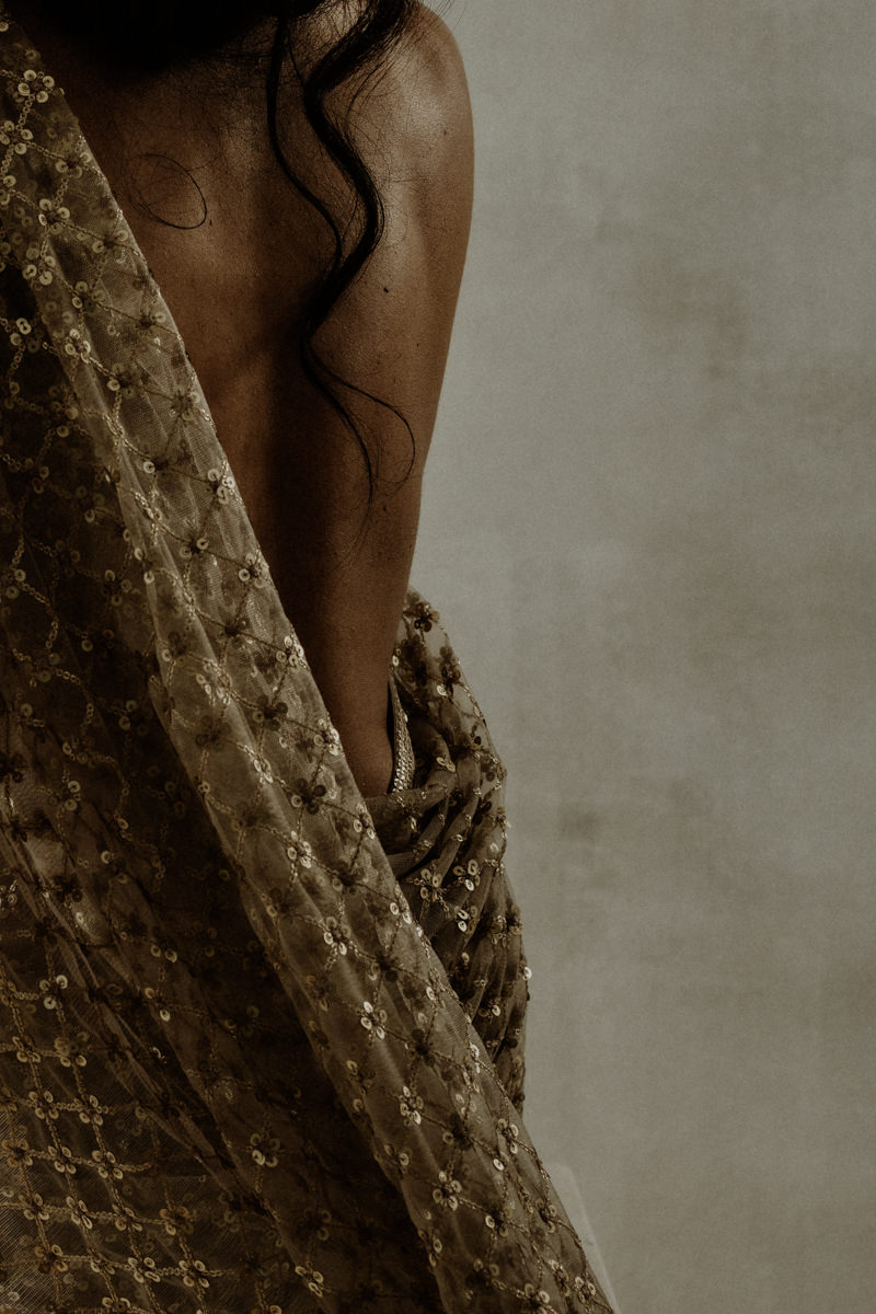 Woman in minimalist boudoir portrait with her back draped in fabric in soft aesthetic